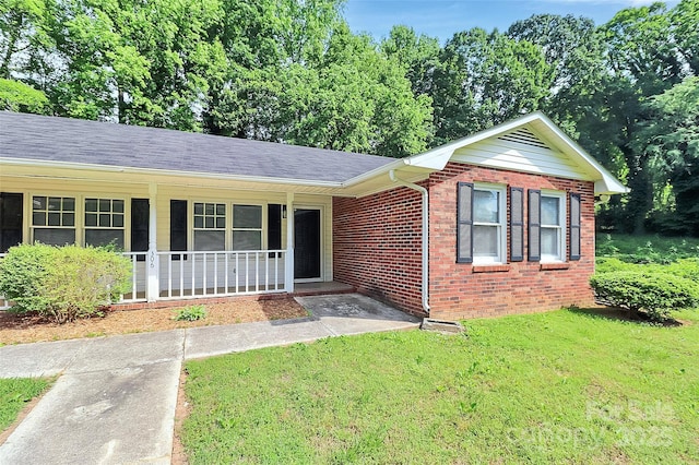 ranch-style home with a front lawn, a shingled roof, and brick siding