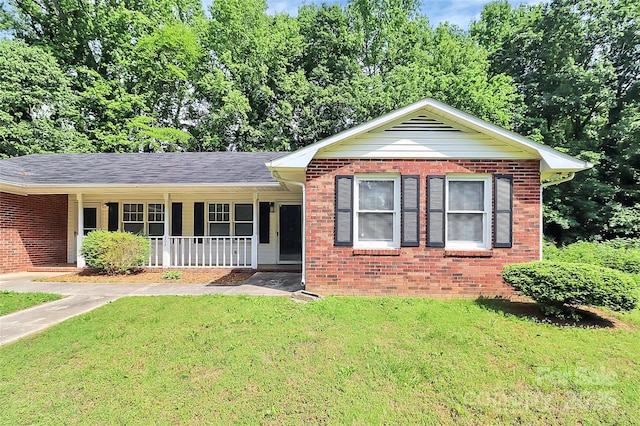 ranch-style home featuring a porch, brick siding, and a front yard