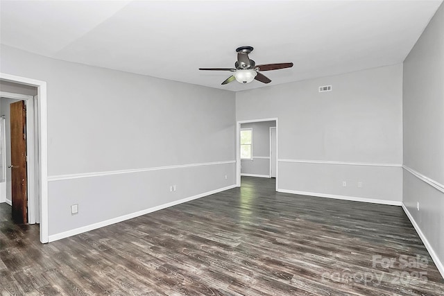 unfurnished room with ceiling fan, baseboards, dark wood-style floors, and visible vents