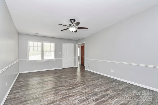 spare room with a ceiling fan, baseboards, and dark wood-style floors