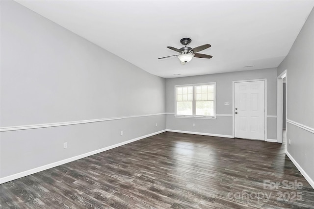 spare room featuring wood finished floors, baseboards, and ceiling fan