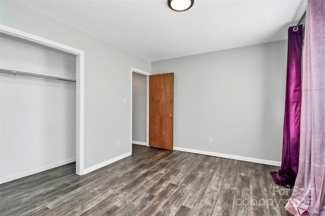 unfurnished bedroom featuring a closet, wood finished floors, and baseboards