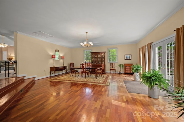 dining space featuring baseboards, ornamental molding, wood finished floors, and a chandelier