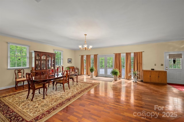 dining space featuring a chandelier, a healthy amount of sunlight, and wood finished floors