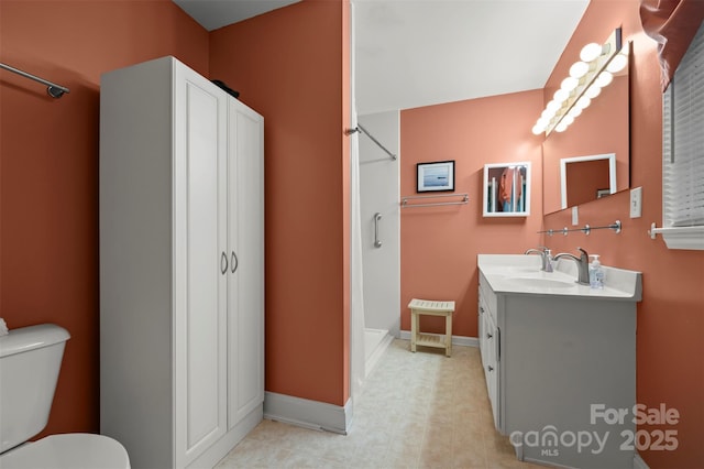 full bath featuring toilet, baseboards, a shower, and vanity