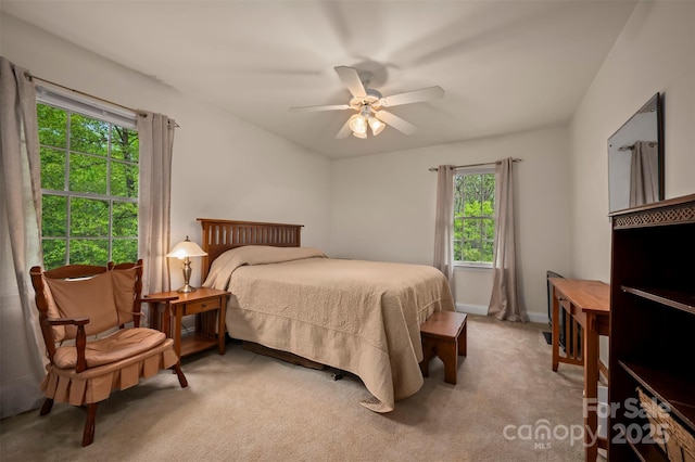 bedroom with baseboards, ceiling fan, and light carpet
