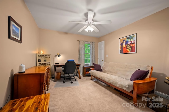carpeted office with a ceiling fan