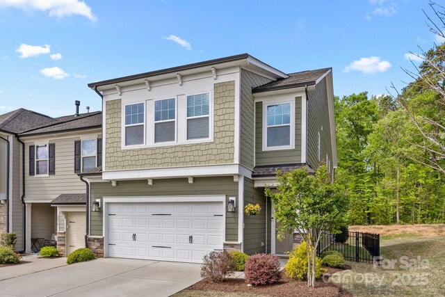 view of property featuring a garage, driveway, and stone siding