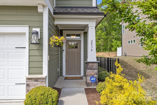 entrance to property with a garage and fence