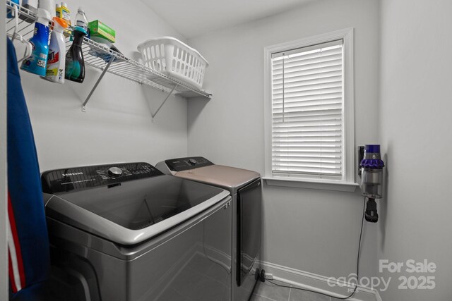 washroom featuring plenty of natural light, laundry area, baseboards, tile patterned floors, and separate washer and dryer