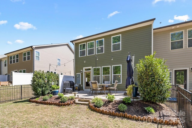 back of house featuring a lawn, a patio area, and fence