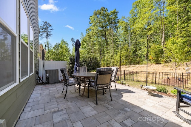 view of patio with central AC, outdoor dining space, and a fenced backyard
