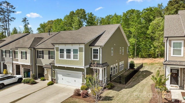 townhome / multi-family property featuring fence, stone siding, roof with shingles, concrete driveway, and an attached garage