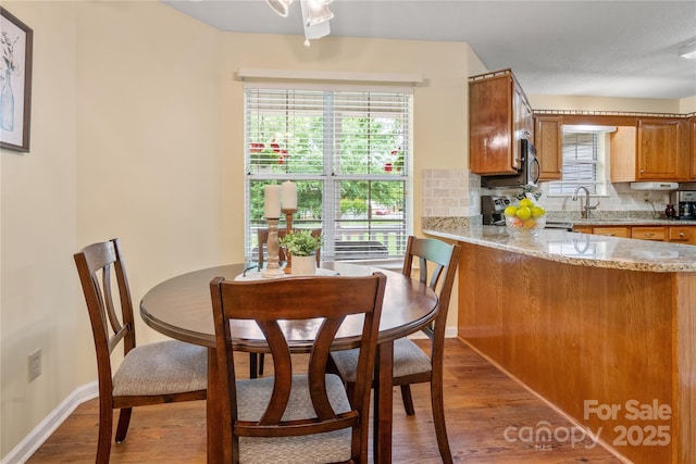 dining room with baseboards and light wood finished floors