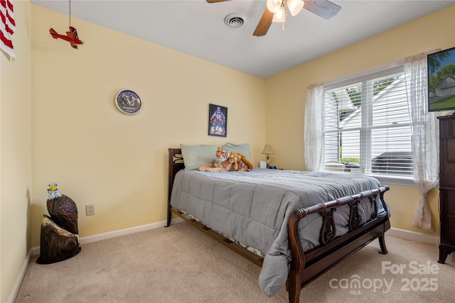 carpeted bedroom featuring visible vents, a ceiling fan, and baseboards