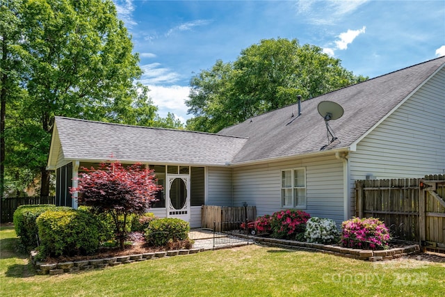 single story home featuring fence, roof with shingles, and a front lawn