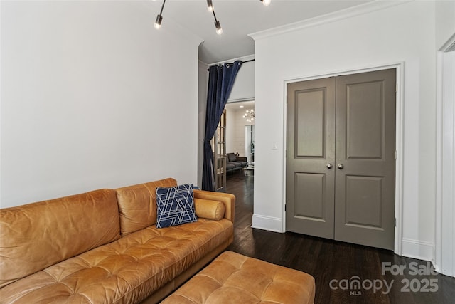 living room featuring dark wood-type flooring, baseboards, and ornamental molding