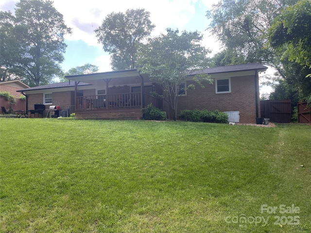 rear view of property featuring brick siding and a lawn