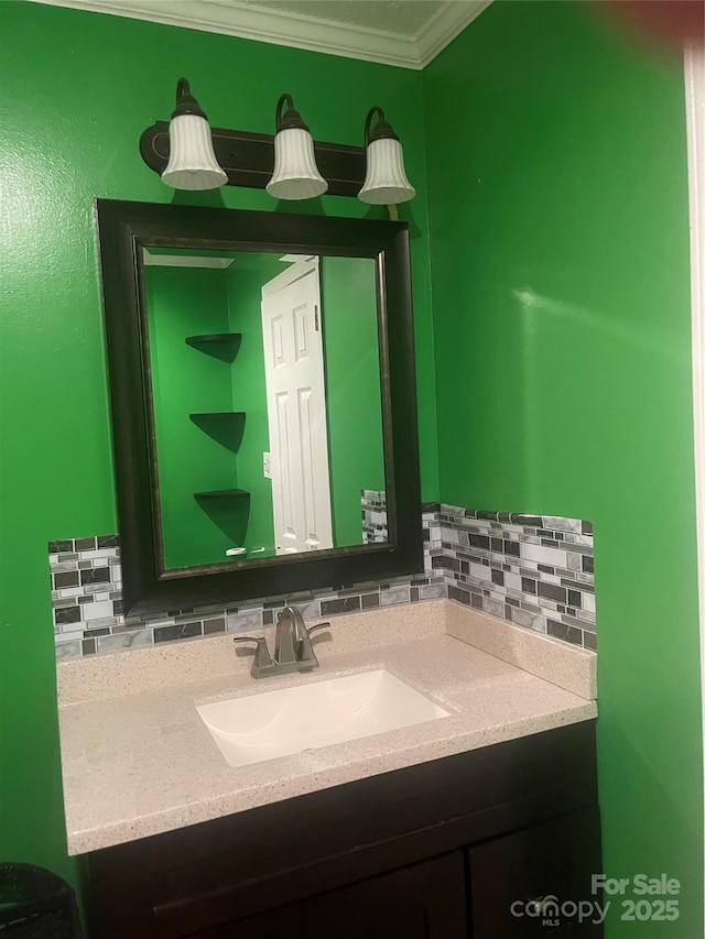 bathroom featuring backsplash, ornamental molding, and vanity