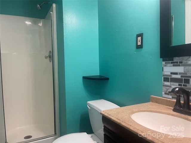 bathroom featuring a shower stall, backsplash, toilet, and vanity
