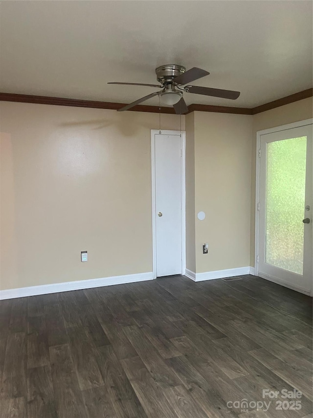 empty room featuring a ceiling fan, dark wood finished floors, crown molding, and baseboards