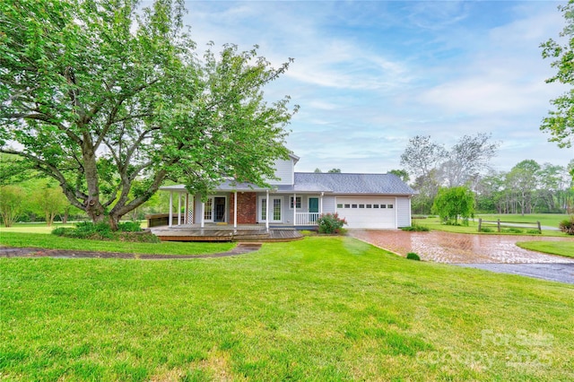 ranch-style house featuring a porch, a front lawn, driveway, and a garage