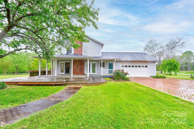 traditional-style home featuring an attached garage, a front lawn, and driveway