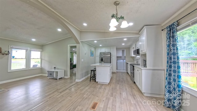 8140 Karriker Rd, Kannapolis, NC 28081 - kitchen with stainless steel appliances, vaulted ceiling, a breakfast bar area, white cabinets, and light countertops