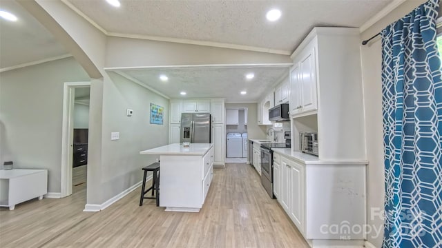 8140 Karriker Rd, Kannapolis, NC 28081 - kitchen featuring stainless steel appliances, a kitchen bar, white cabinets, light wood finished floors, and vaulted ceiling