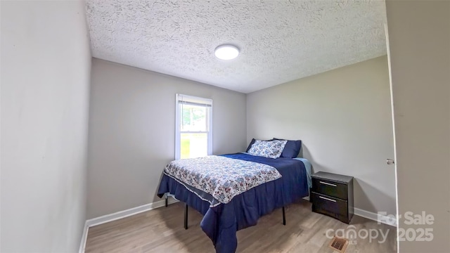 8140 Karriker Rd, Kannapolis, NC 28081 - bedroom with wood finished floors, baseboards, and a textured ceiling