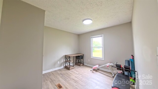 8140 Karriker Rd, Kannapolis, NC 28081 - workout room featuring a textured ceiling, wood finished floors, and baseboards