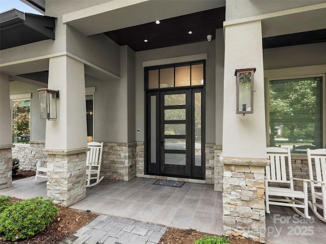 60 Running Creek Trl, Arden, NC 28704 - view of exterior entry with stone siding, stucco siding, and covered porch