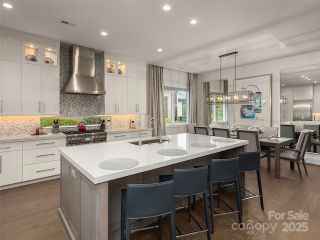 60 Running Creek Trl, Arden, NC 28704 - kitchen with wall chimney exhaust hood, a sink, a kitchen bar, decorative backsplash, and light countertops