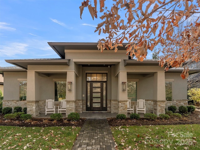 60 Running Creek Trl, Arden, NC 28704 - doorway to property featuring stone siding, stucco siding, a porch, and a lawn