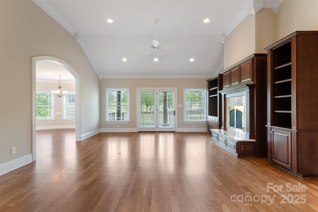 unfurnished living room featuring vaulted ceiling, ornamental molding, light wood-style flooring, and ceiling fan with notable chandelier