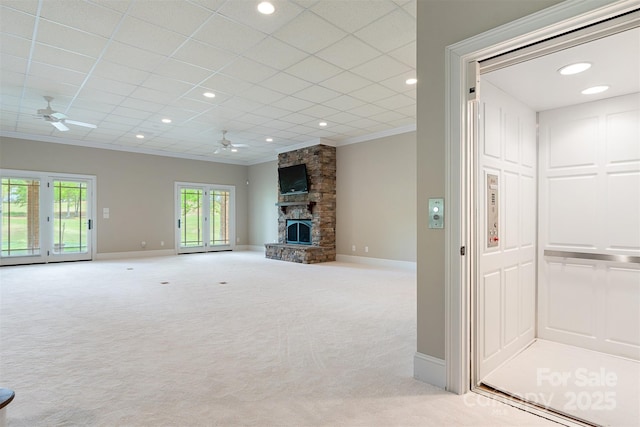 unfurnished living room featuring light carpet, ornamental molding, baseboards, and ceiling fan