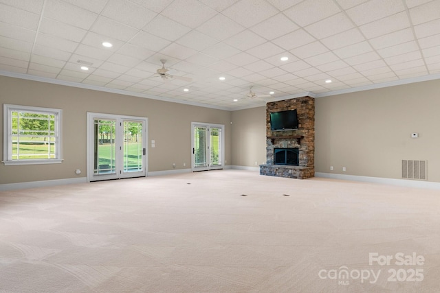 unfurnished living room with visible vents, ornamental molding, carpet floors, baseboards, and a fireplace