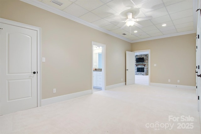 carpeted empty room featuring ornamental molding, visible vents, a ceiling fan, and a drop ceiling