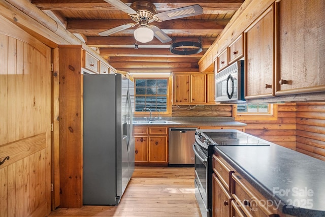 1154 Woodrow Pl, Lenoir, NC 28645 - kitchen featuring stainless steel appliances, rustic walls, light wood-type flooring, brown cabinets, and beamed ceiling