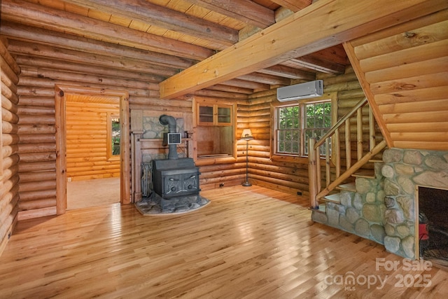 1154 Woodrow Pl, Lenoir, NC 28645 - unfurnished living room with an AC wall unit, beamed ceiling, a wood stove, wood-type flooring, and wooden ceiling
