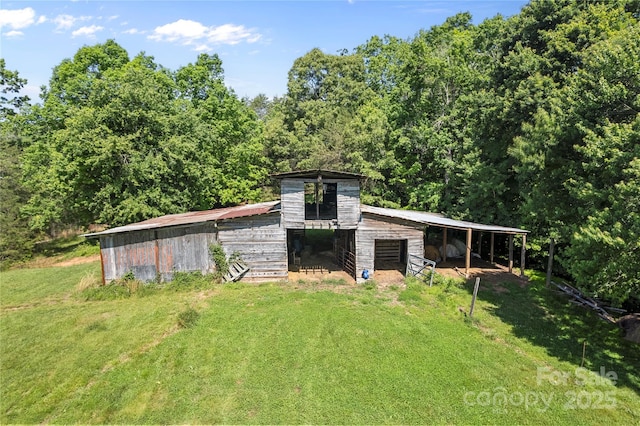 1154 Woodrow Pl, Lenoir, NC 28645 - view of pole building featuring a forest view, an exterior structure, and a lawn