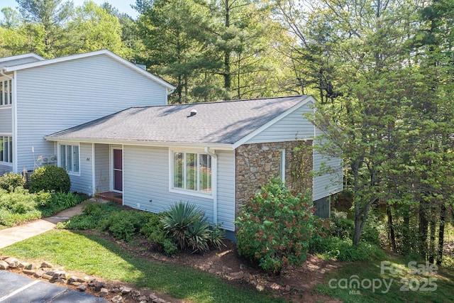 view of front of home with stone siding and a shingled roof
