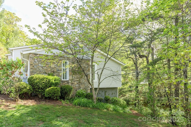 view of property exterior with a yard and stone siding