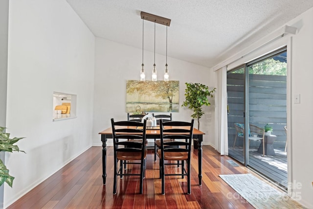 dining room with lofted ceiling, a textured ceiling, dark wood finished floors, and baseboards