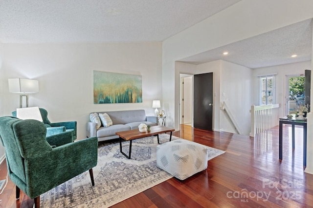 living area featuring a textured ceiling, wood finished floors, recessed lighting, and baseboards