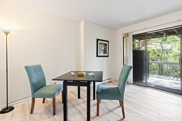 office area featuring a textured ceiling, light wood finished floors, and a baseboard heating unit