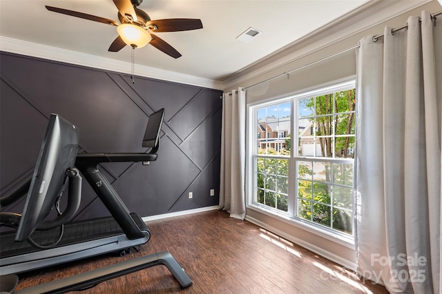 workout area with crown molding, wood finished floors, a ceiling fan, and baseboards