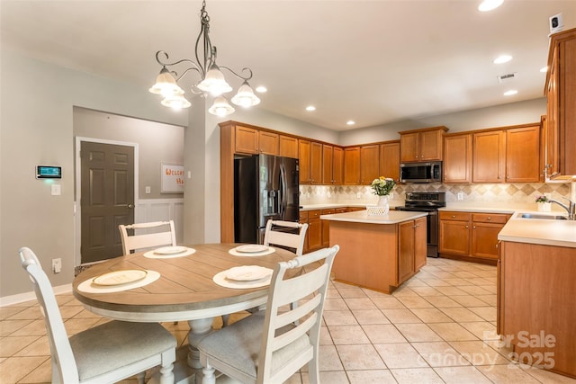 kitchen featuring stainless steel appliances, a sink, decorative backsplash, a kitchen island, and recessed lighting