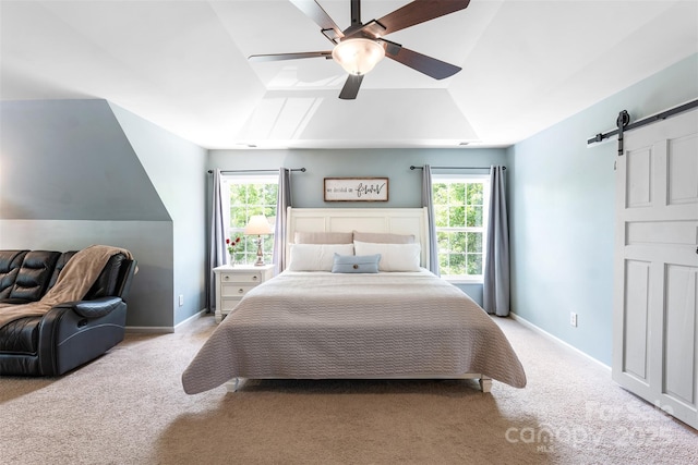carpeted bedroom with a barn door, multiple windows, lofted ceiling, a ceiling fan, and baseboards