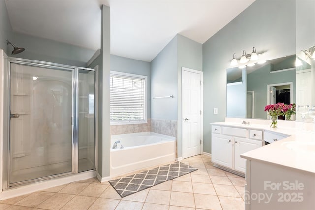 bathroom with tile patterned flooring, a stall shower, a garden tub, and vanity